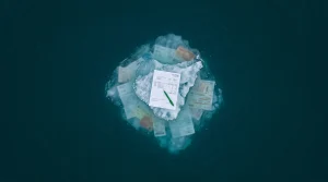 Navigating the Perils: Common Blunders in Education Funding, Local Jobs, Personal Finance, and Small Business Aerial view of an iceberg representing education costs, with a tuition statement on the visible tip and hidden expenses like lab fees and textbooks submerged below the surface.