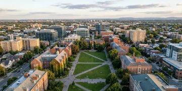 Aerial view of a vibrant university campus nestled within a bustling city at sunset, symbolizing education funding as an investment in human capital.